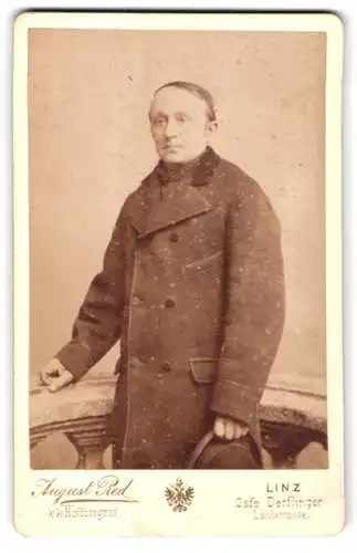 Fotografie August Red, Linz, Landstrasse, Herr im Mantel mit ernstem Ausdruck