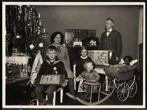Fotografie Familienportrait zu Weihnachten, Eltern mit Kindern, Spielzeug Schaukelpferd, Märklin Baukasten