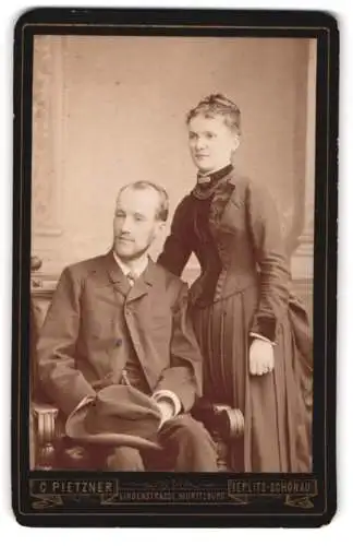 Fotografie C. Pietzner, Teplitz-Schonau, Lindenstrasse, Moritzburg, Porträt eines sitzenden Mannes nebst stehenden Frau