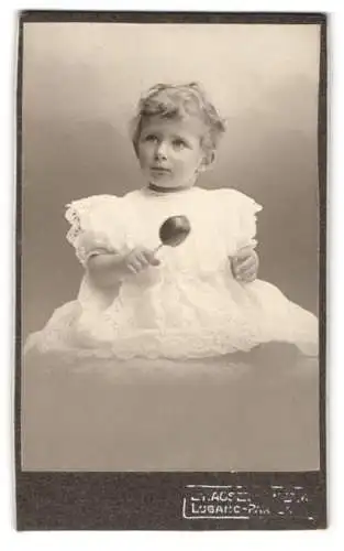 Fotografie E. Hauser-Pricam, Lugano-Paradiso, Porträt eines kleinen Kindes mit Rassel