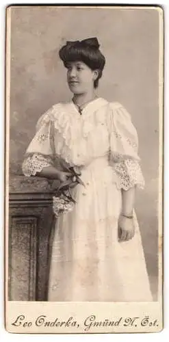 Fotografie Leo Onderka, Gmünd N. Öst., Junge Frau im weissen Kleid mit Blumen, 1906