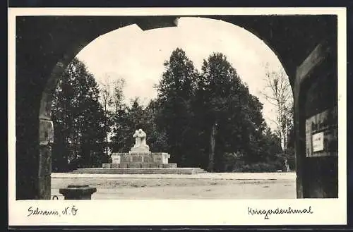 AK Schrems /N.-Ö., Kriegerdenkmal von einem Torbogen aus