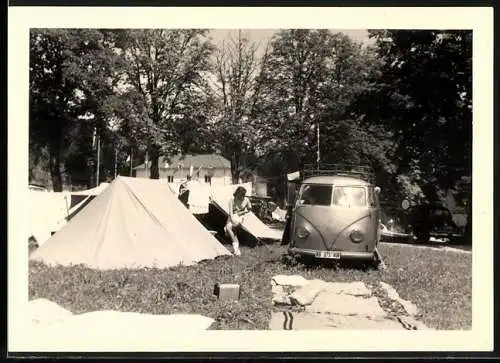 Fotografie Auto Volkswagen VW Bulli T1 auf einem Campingplatz, hübsche junge Frau legt Wäsche zusammen