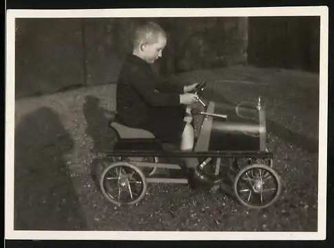 Fotografie Spielzeug Auto, Knabe fährt mit Tretauto / Draisine