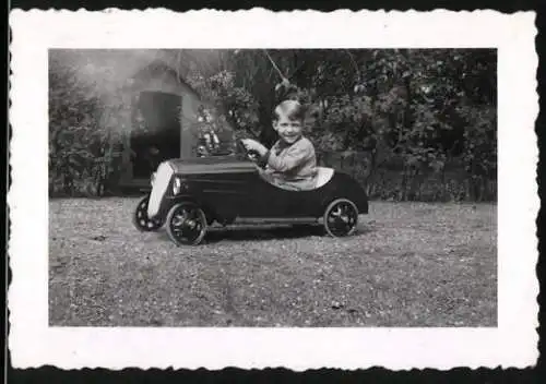 Fotografie Spielzeug Auto, Knabe fährt mit Tretauto - Seifenkiste