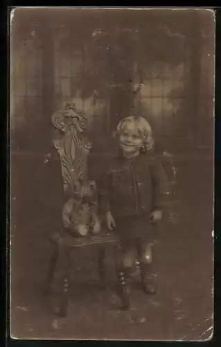 Foto-AK Kind steht neben einem Stuhl mit einem Teddy