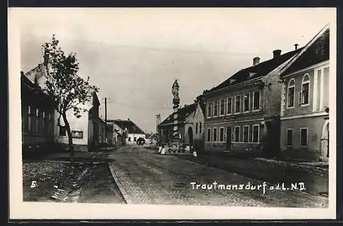 AK Trautmannsdorf a. d. L., Strassenpartie mit Denkmal