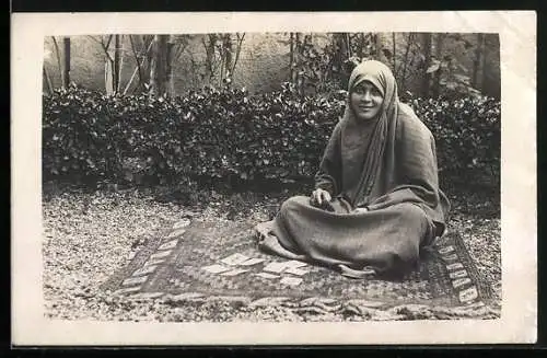 Foto-AK Arabische Frau sitzt auf einem Teppich