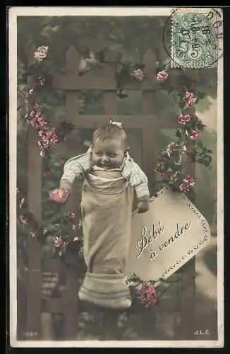 AK Baby in einem Sack an einem Zaun