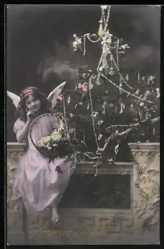 AK Weihnachtsengel mit Korb vor einem Tannenbaum