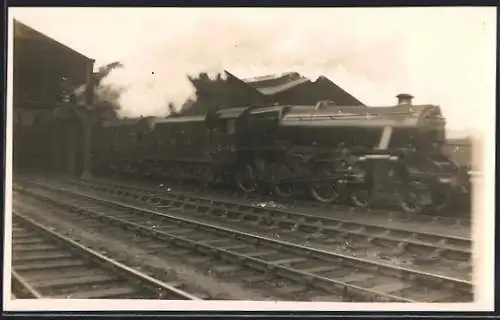 Foto-AK Dampflokomotive mit Personenzug bei der Ausfahrt aus einem Bahnhof, englische Eisenbahn