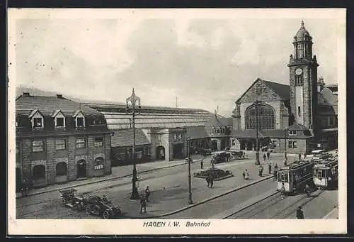 AK Hagen i. W., Strassenpartie mit Bahnhof und Strassenbahnen