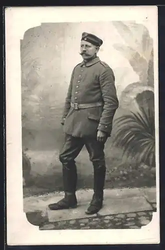 Foto-AK Soldat in Uniform vor Gartenkulisse