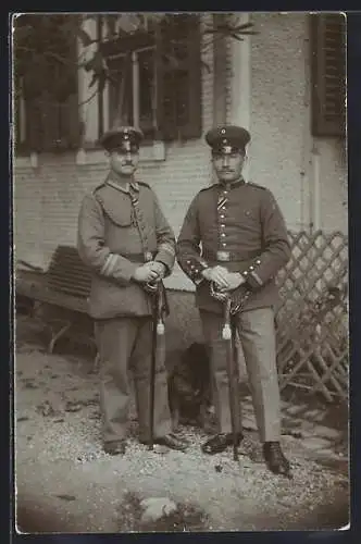 Foto-AK Zwei Soldaten mit aufgestützen Degen vor einem Gebäude, Uniformfoto, 1915