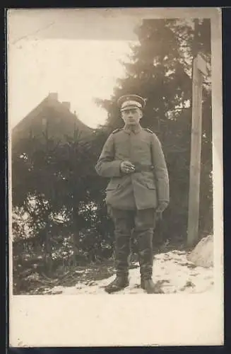 Foto-AK Soldat mit Schirmmütze im Schnee, Uniformfoto
