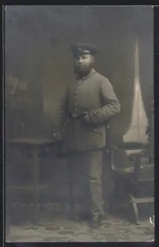 Foto-AK Soldat mit Schirmmütze und Vollbart, Uniformfoto