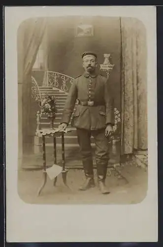 Foto-AK Soldat in einem Treppenhaus, Uniformfoto