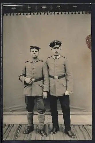 Foto-AK Zwei Soldaten vor Fotokulisse, Wickelgamaschen, Uniformfoto