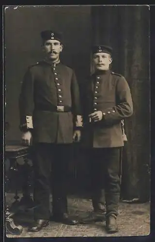 AK Zwei Soldaten mit Zigarette in einer Fotokulisse, Kragenspiegel, Uniformfoto
