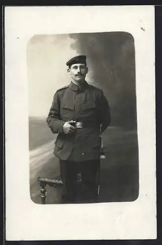 Foto-AK Soldat mit Quaste vor Fotokulisse, Uniformfoto