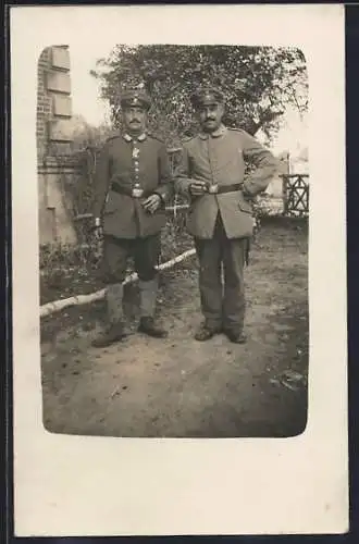 Foto-AK Zwei Soldaten mit Schirmmützen in einem Garten, Kragenspiegel, Uniformfoto