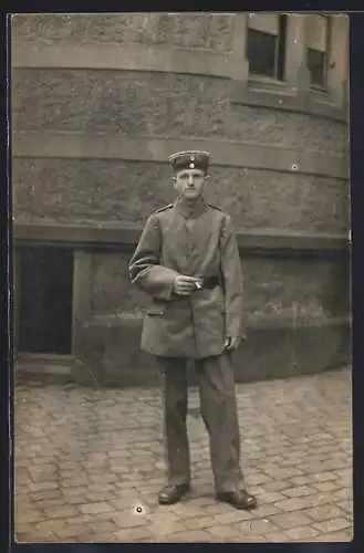 Foto-AK Junger Soldat mit Zigarette vor einem Gebäude, Uniformfoto