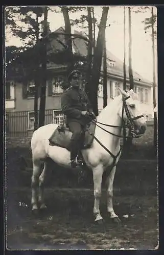 Foto-AK Soldat mit Schirmmütze zu Pferde vor einer Villa, Uniformfoto
