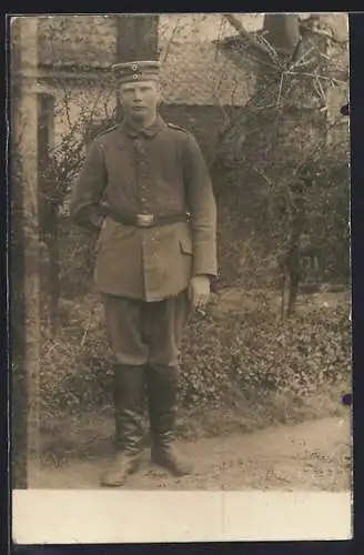 Foto-AK Soldat mit Zigarette vor einem Gebäude, Uniformfoto, 1916