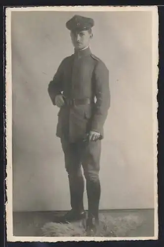 Foto-AK Soldat mit Schirmmütze und Handschuhen, Uniformfoto