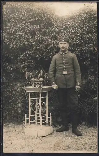 Foto-AK Soldat mit Kragenspiegel und Zigarette in einem Garten, Uniformfoto