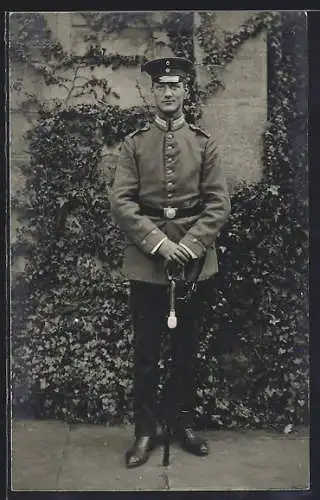 Foto-AK Soldat mit Kragenspiegel und Degen vor einem Gebäude, Uniformfoto