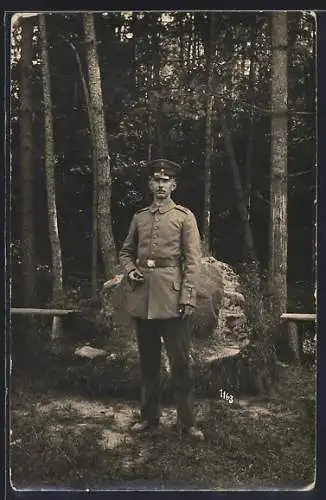 Foto-AK Soldat mit Schirmmütze vor einem Waldstück, Uniformfoto
