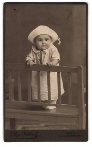 Fotografie Aug. Kühnel, Wien, Reithofferplatz 7, Kleinkind mit weisser Mütze