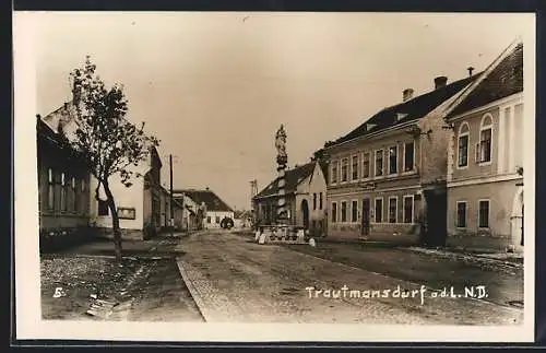 AK Trautmannsdorf a. d. L., Strassenpartie mit Denkmal