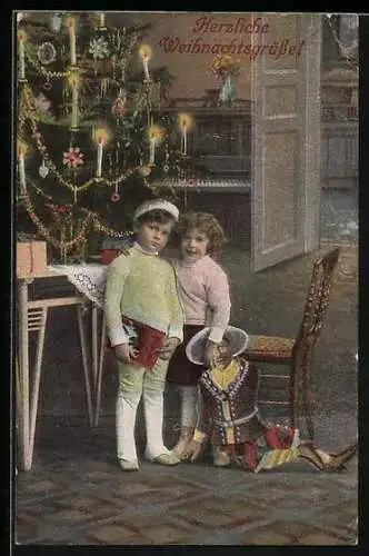 AK Kinderpaar mit Puppe am Weihnachtsbaum, Weihnachtsgruss