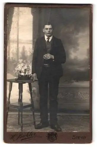 Fotografie H. Bichler, Steyr, Bahnhofstrasse, Porträt eines Mannes mit Blumenstrauss
