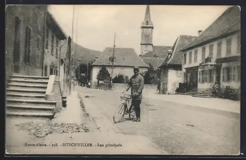 AK Bitschwiller /Haute-Alsace, Rue principale avec homme et bicyclette devant l`église