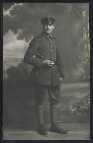 Foto-AK Soldat in Feldgrau Uniform mit Schirmmütze