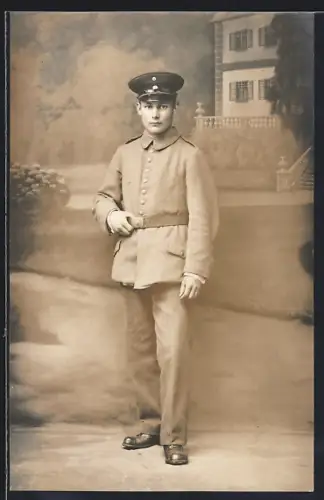 Foto-AK Soldat in Feldgrau Uniform mit Schirmmütze