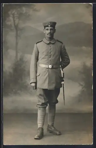 Foto-AK Soldat in Feldgrau Uniform mit Bajonett und Krätzchen