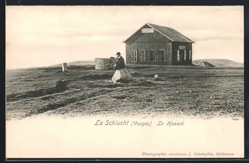 AK La Schlucht /Vosges, Le Hohneck avec une cabane en bois et un personnage assis sur une pierre
