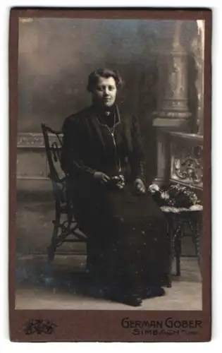 Fotografie German Gober, Simbach, Frau in dunklem Kleid mit Blumenstrauss