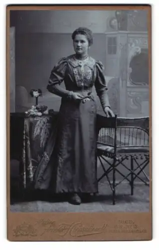 Fotografie Arnold Hirnschrodt, Ried im Innkreis, Frau in elegantem Kleid neben Tisch und Stuhl