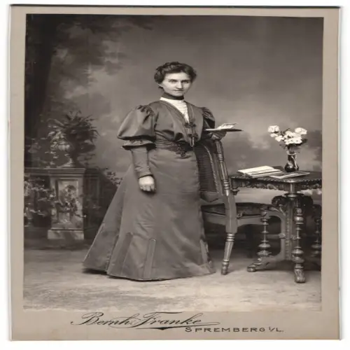Fotografie Bernh. Franke, Spremberg, Elegante Dame neben Tisch mit Blumen