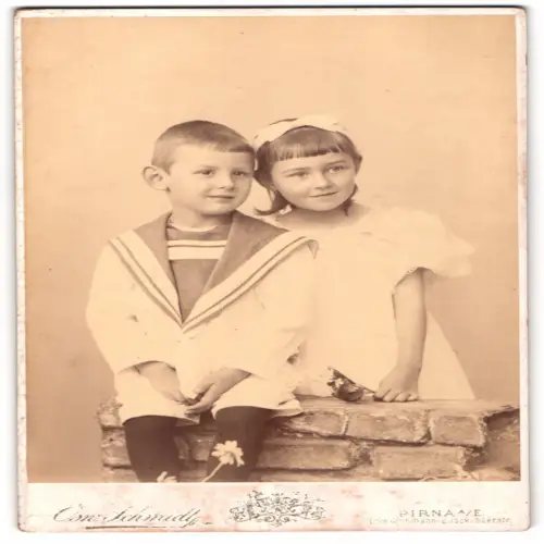 Fotografie Osw. Schmidt, Pirna, Grohmannstrasse, Porträt zweier Kinder an einer Mauer, 1897