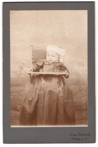 Fotografie Curt Schmidt, Prettin a. E., Kleinkind auf Stuhl sitzend