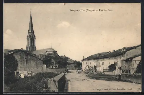 AK Dogneville /Vosges, Rue du Pont avec vue sur l`église et les bâtiments environnants