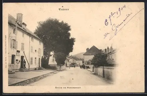 AK Vagney, Route de Remiremont avec vue sur les maisons et les montagnes en arrière-plan