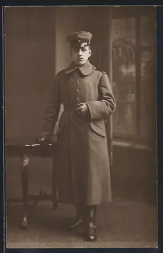 AK Soldat in Mantel mit Schirmmütze