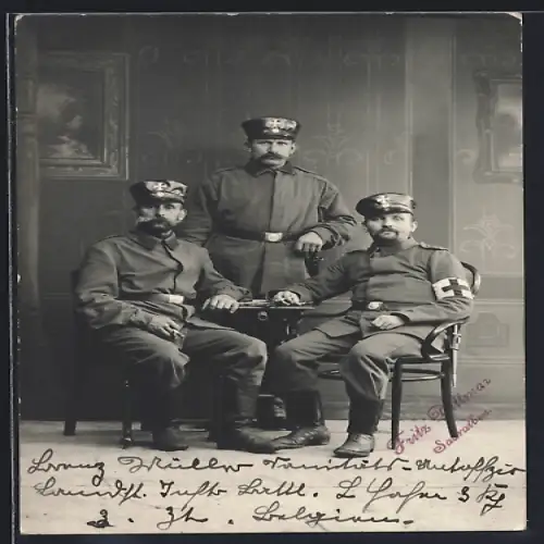 Foto-AK Drei Landwehr-Soldaten in Uniform, 1 mit Sanitäter-Armbinde